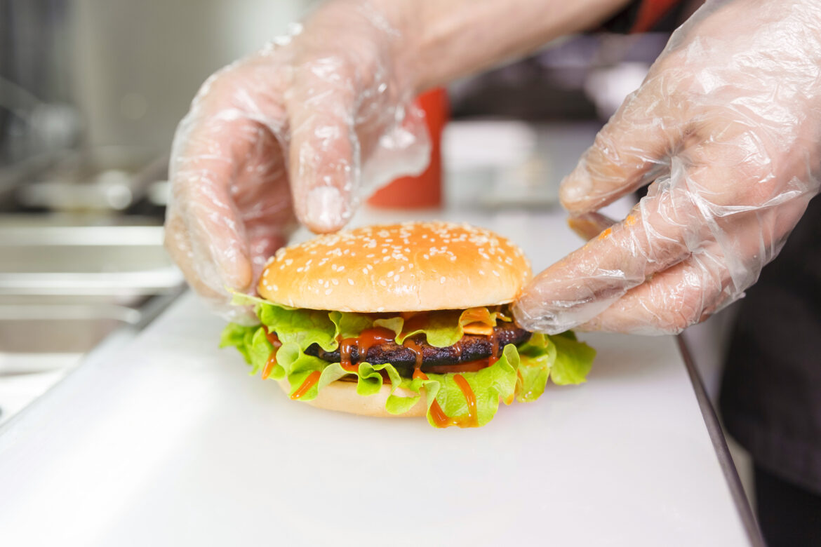 The,Chef’s,Hands,Demonstrate,The,Finished,Burger.,Preparing,Burger,In